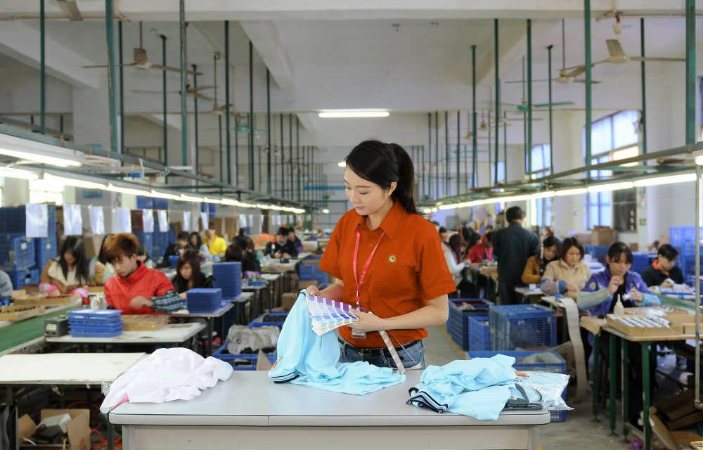 An image depicting the Jinfeng Apparel production team meticulously working on garment details, emphasizing the importance of each step in the manufacturing process. The image highlights our commitment to quality and precision, even when preparing for expedited orders for strategic partners.n garments
