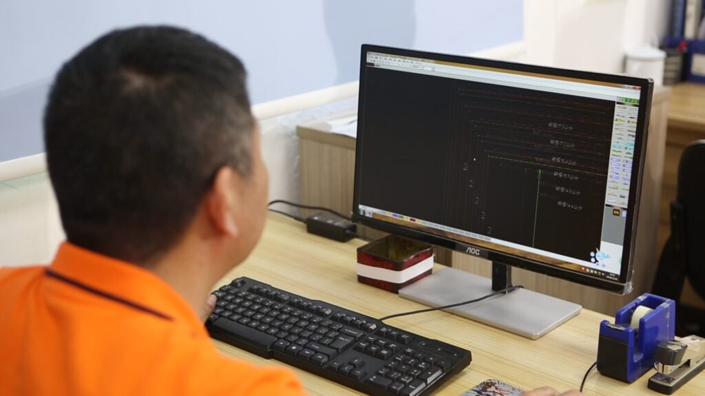 An image showing a pattern maker using grading software to adjust a base pattern for different sizes, symbolizing the precision and expertise involved in the grading process.