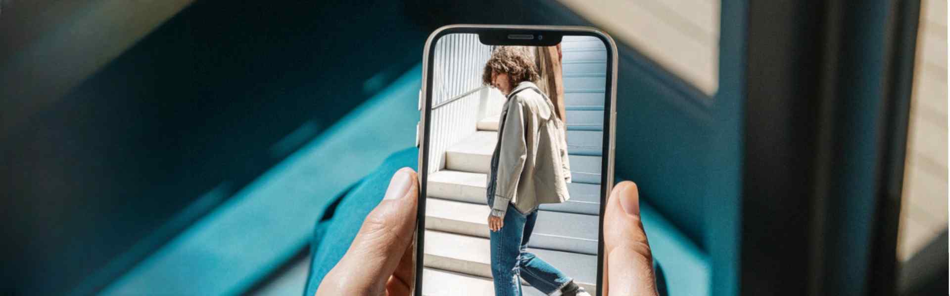 A person viewing a casual outfit photo on their smartphone while seated indoors.