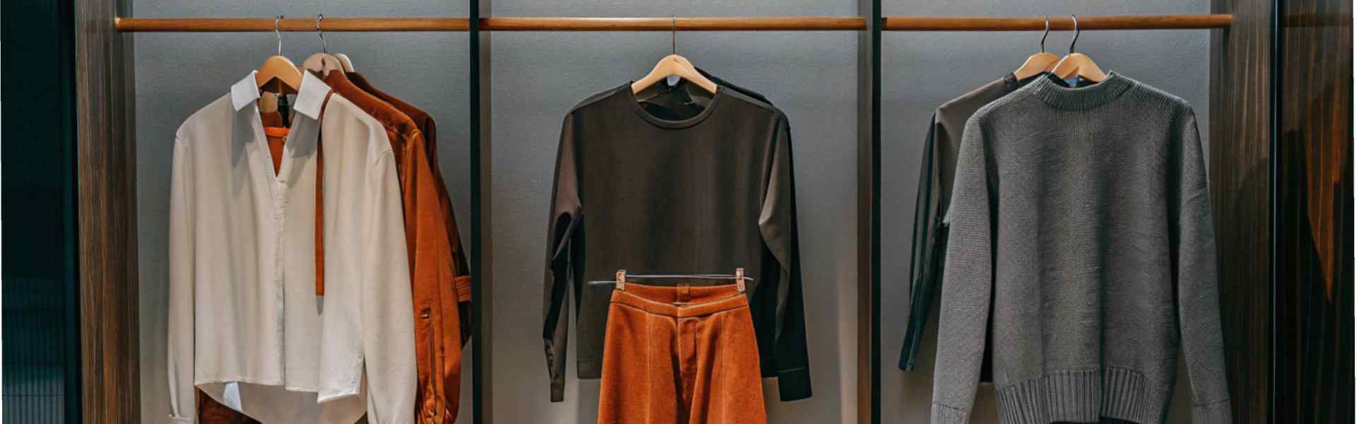 Clothing display with neutral tops, burnt orange pants, and shoes.