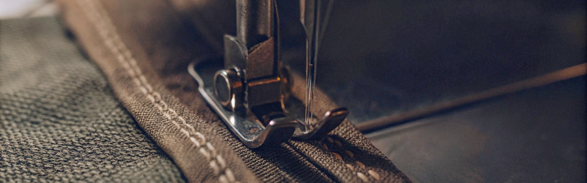 Close-up of a sewing machine stitching thick fabric.