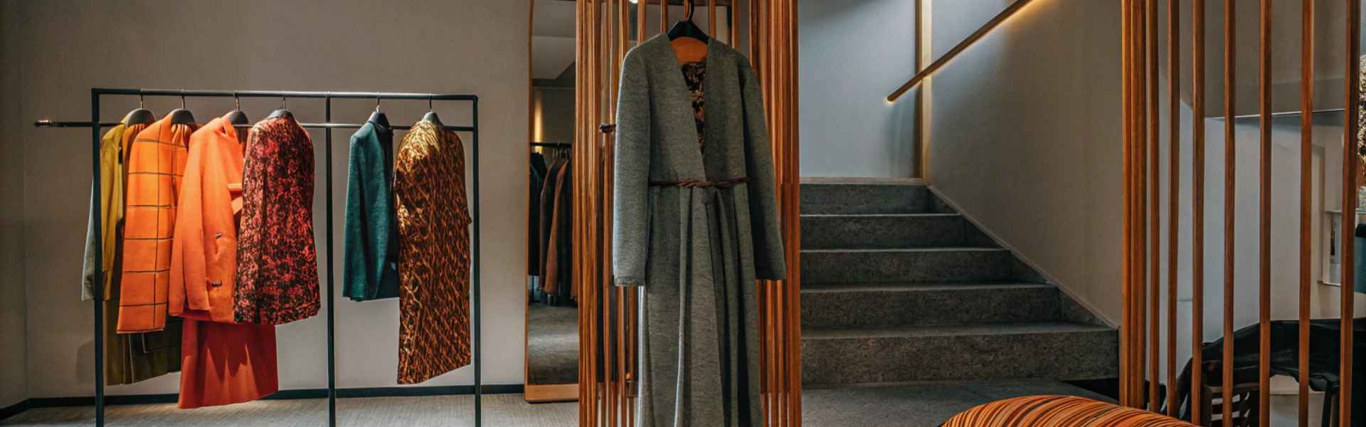 A clothing rack showcasing colorful coats in orange, green, and patterned designs.