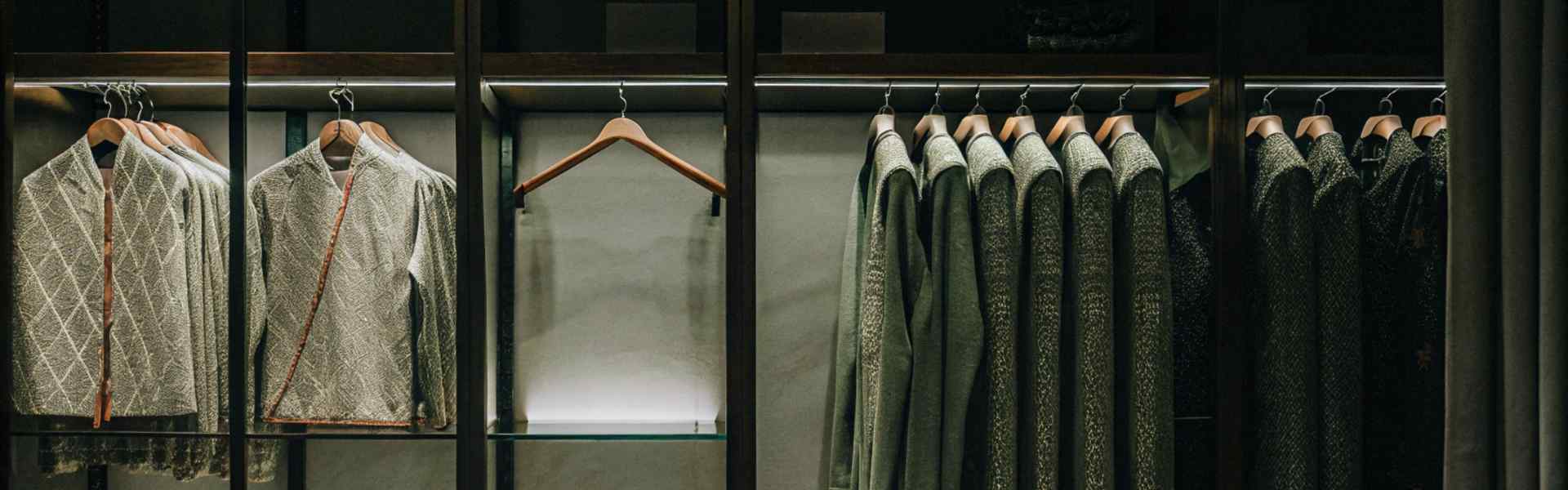 Elegant closet featuring neatly arranged traditional-style jackets and folded fabrics.