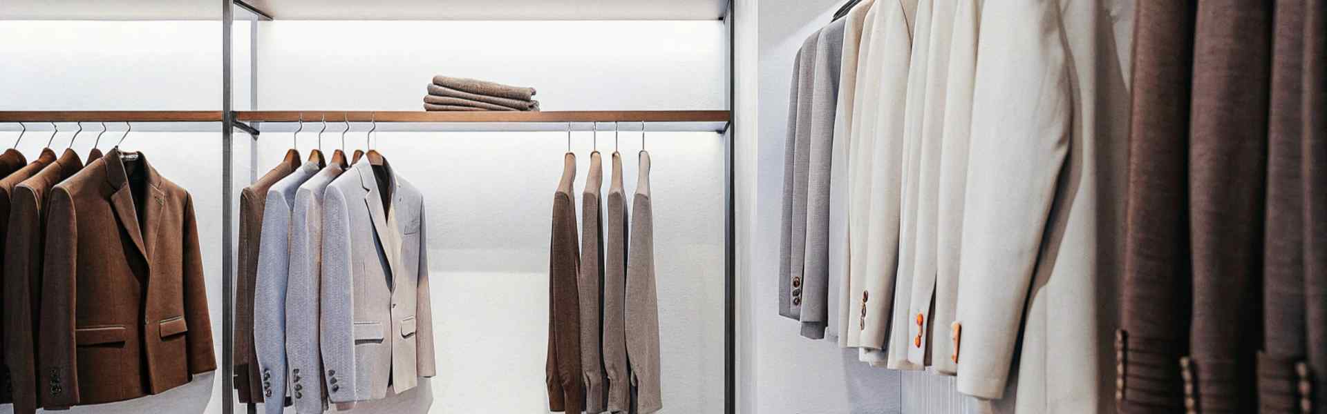 Clothing store showcasing neatly arranged jackets and sweaters in neutral tones.