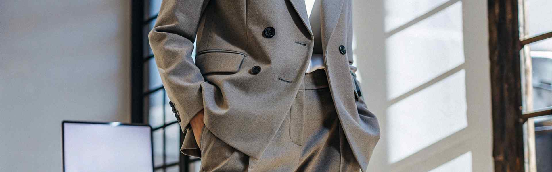 Close-up of a stylish grey suit in a modern office setting.