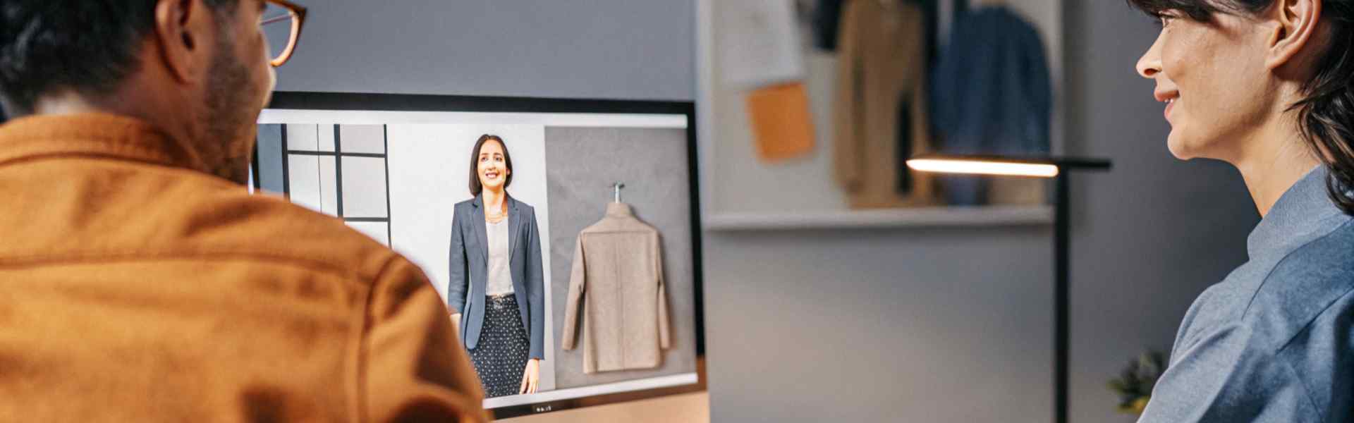 Two people watching a virtual presentation of a fashion collection on a computer screen.