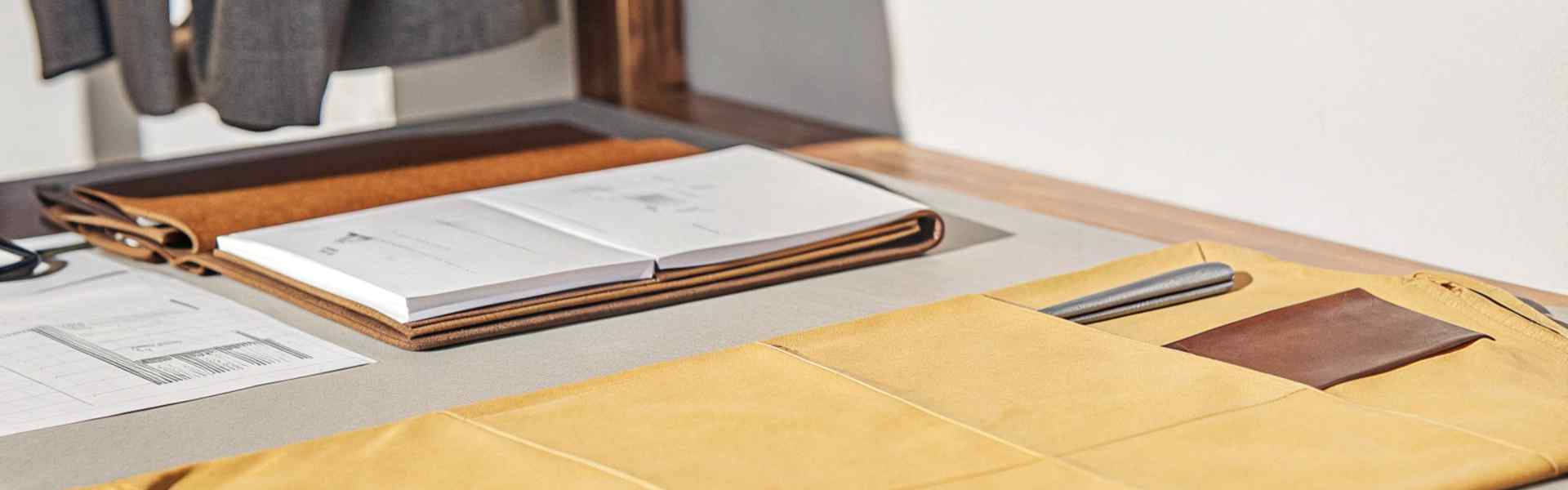 A neatly organized workspace featuring fabric samples, a notebook, and design tools in natural light.