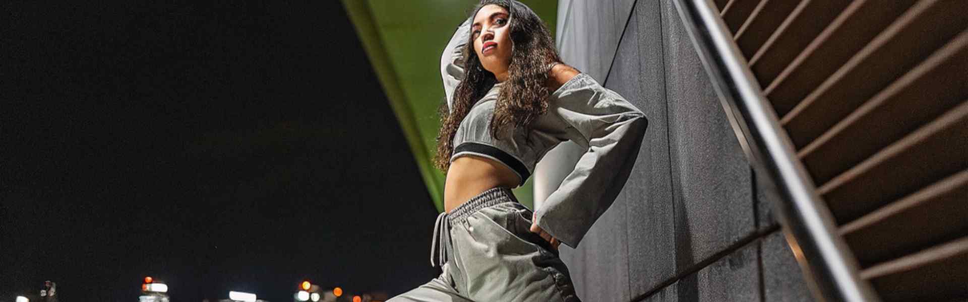 Confident woman posing in streetwear at night.