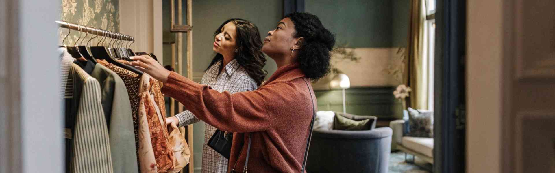 Two women browsing clothes in a stylish boutique.