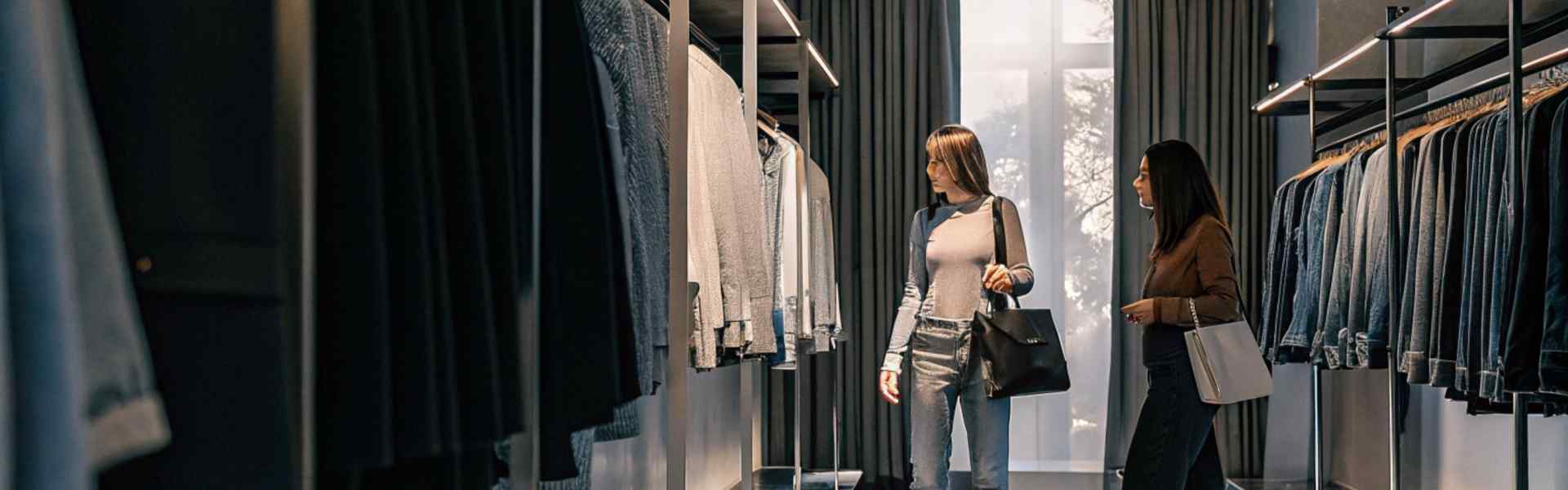 Two women shopping for clothes in a modern boutique.