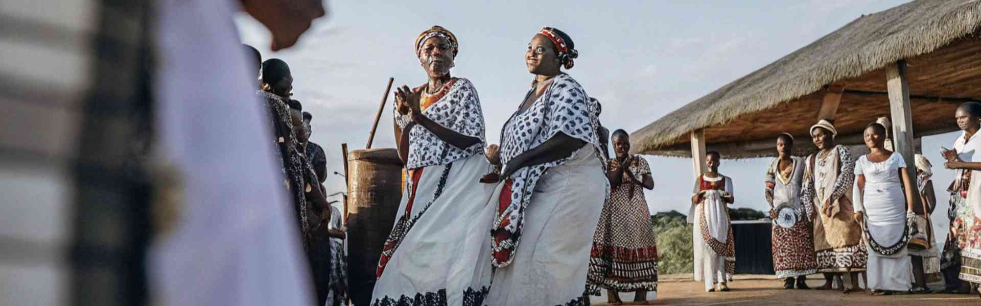 Women in traditional African attire dancing in a cultural celebration.