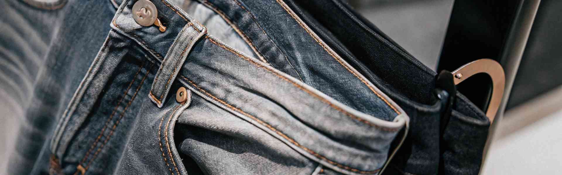 Light and dark wash jeans hanging on a clothing rack.