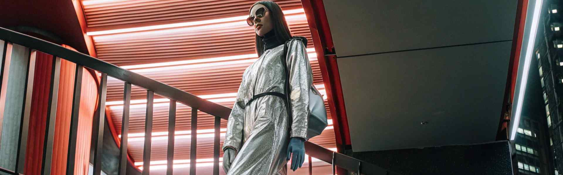 Woman in a metallic jumpsuit with futuristic style.