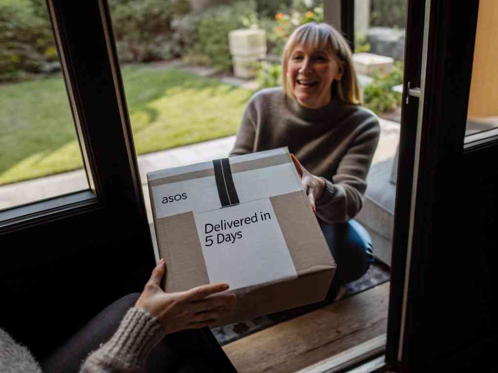 A smiling woman receiving an ASOS package at her doorstep, labeled "Delivered in 5 Days."