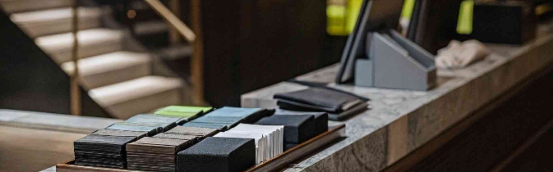 A modern store counter with fabric samples and digital devices.