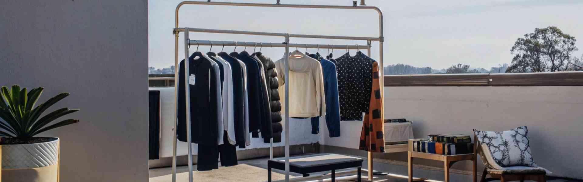 A thrift clothing rack displayed outdoors with various garments.