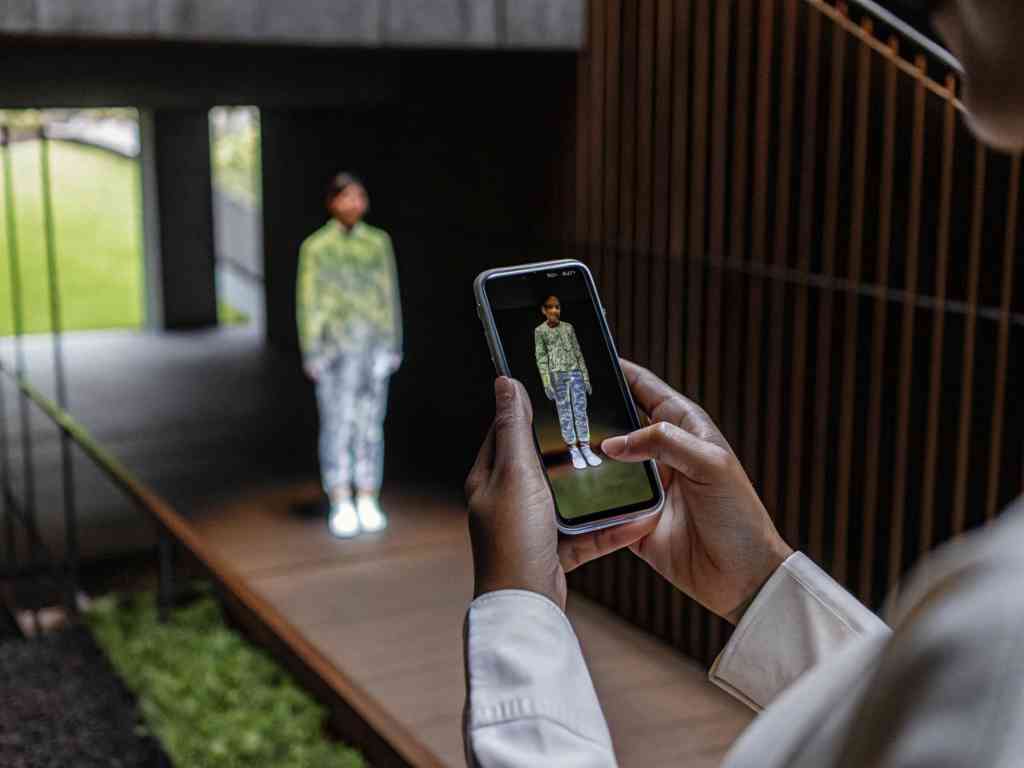 Person using phone to view digital fashion model.