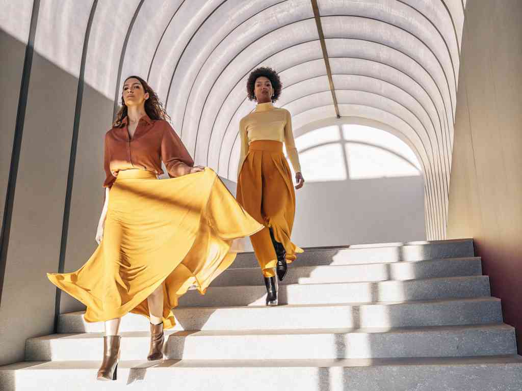 Women descending stairs in bright skirts