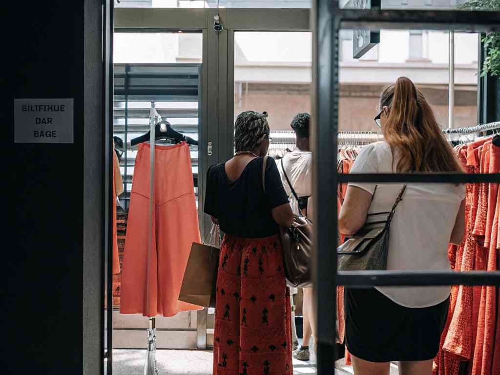 Shoppers browsing colorful clothing in a boutique store.