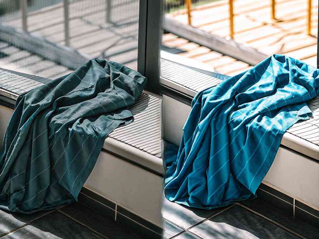 Teal and turquoise fabric draped by window light