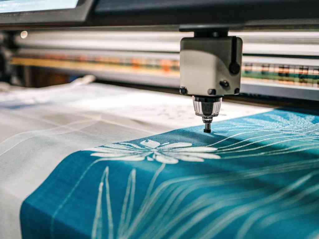 Automated embroidery machine stitching floral patterns on fabric