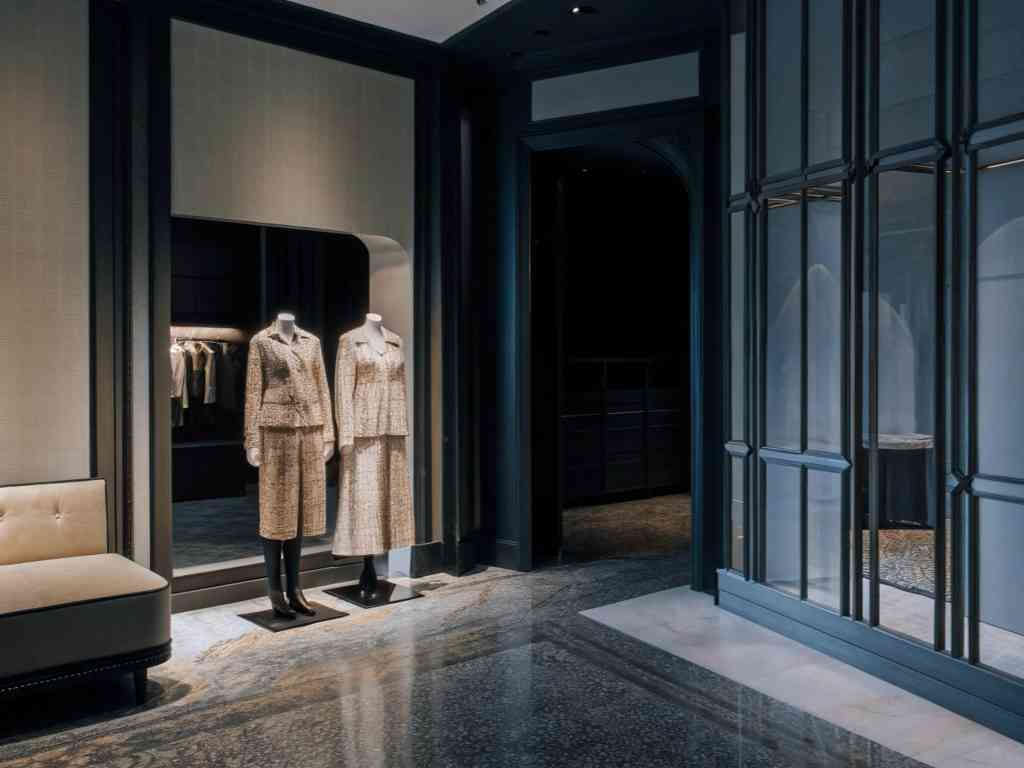 A luxury boutique interior with mannequins dressed in tweed outfits.