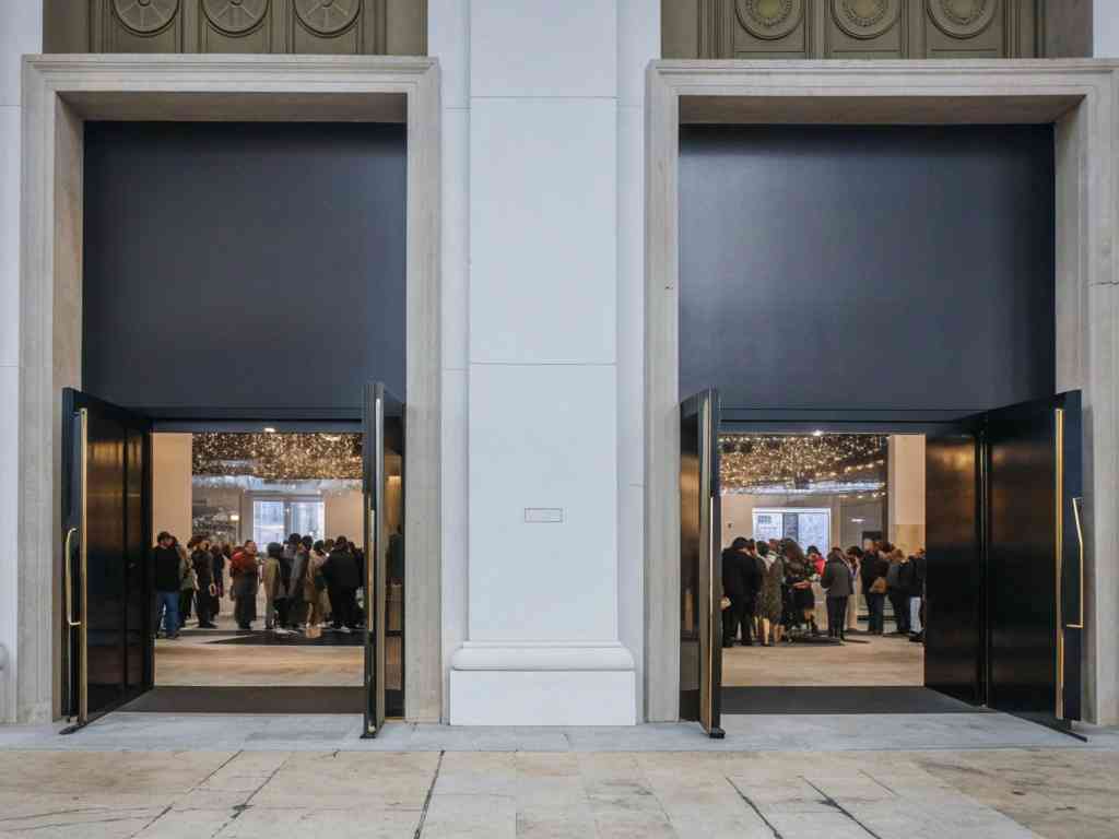 Two open doors leading to a crowded event space with no visible signage.