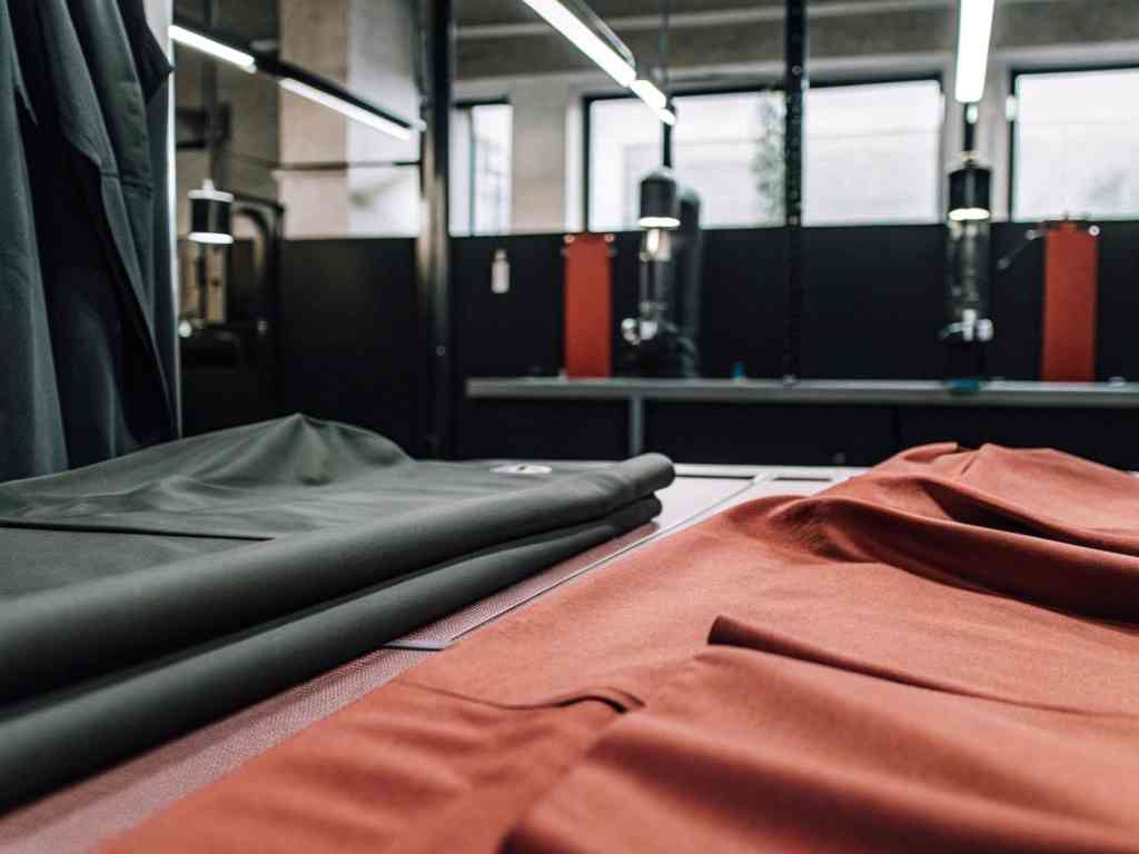 Dark green and rust-colored fabrics laid out in a textile workshop.