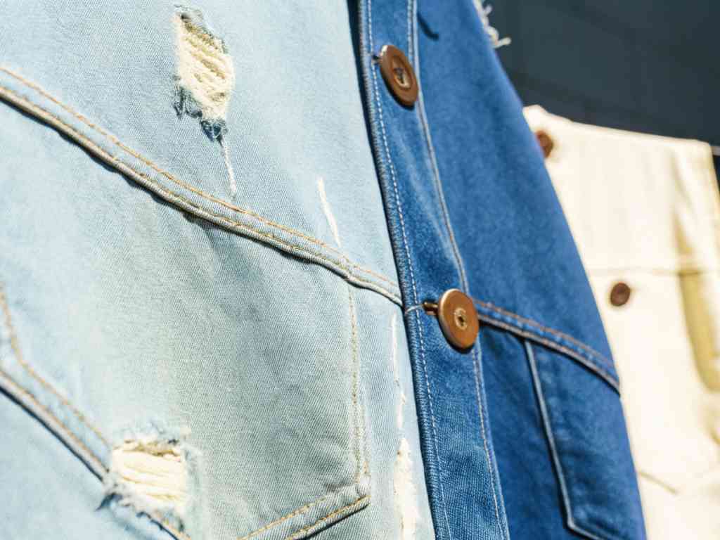 Close-up of distressed denim jackets in various shades