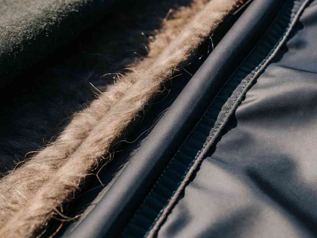 Close-up of synthetic and fur-like fabric layers with stitching.