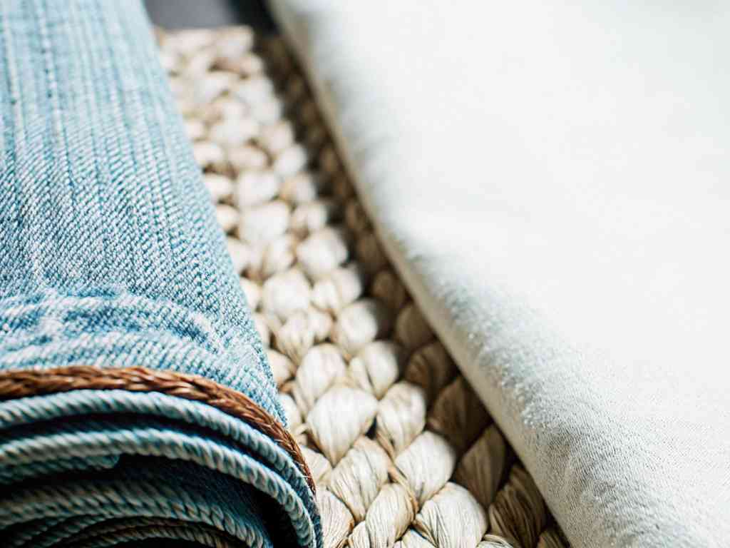 Close-up of blue and white fabrics on a woven mat.