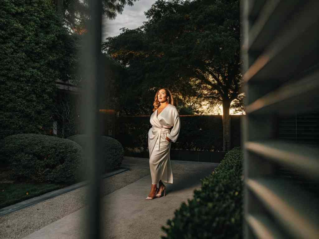 Woman in ivory satin dress at sunset garden