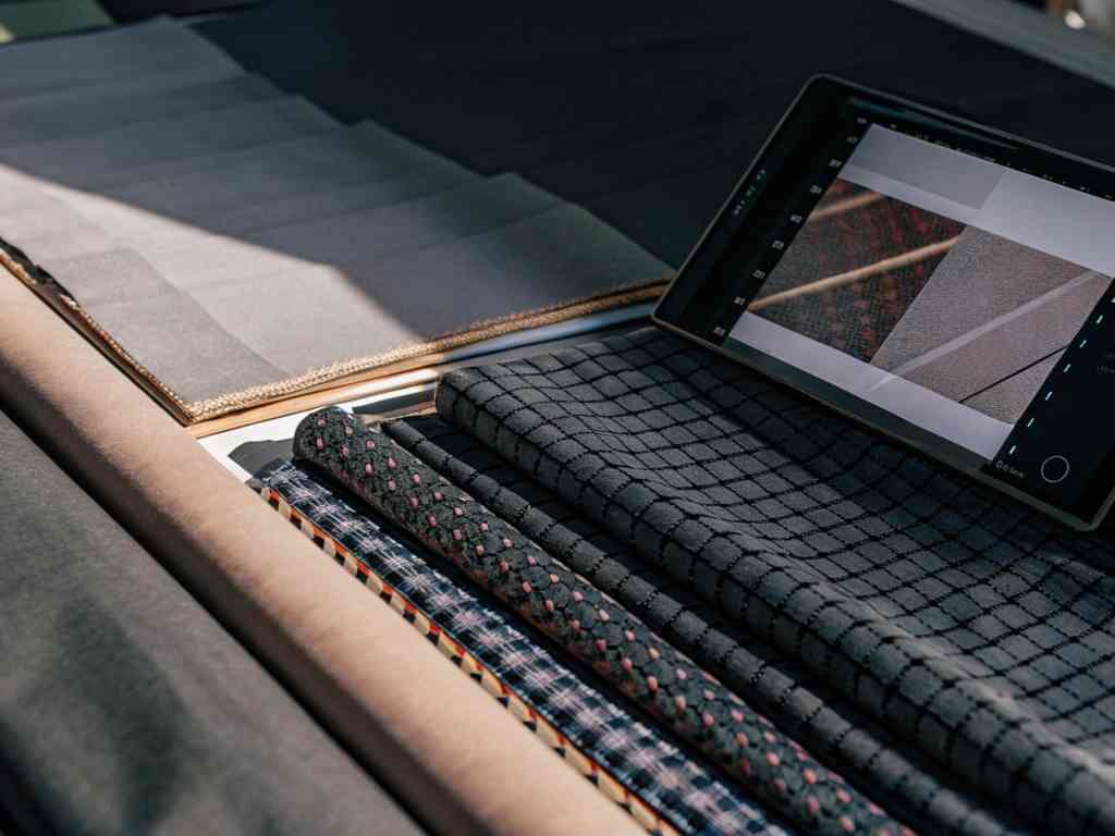 Various dark fabric swatches and tablet with textile designs