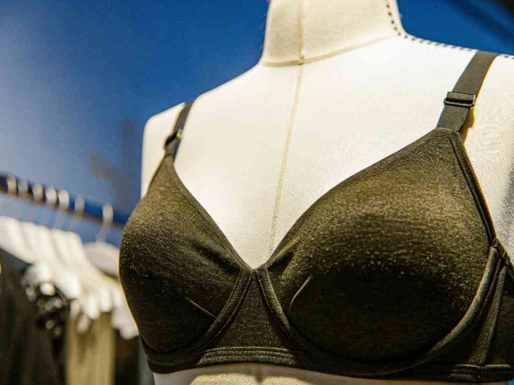 Black textured bra displayed on mannequin with blue backdrop