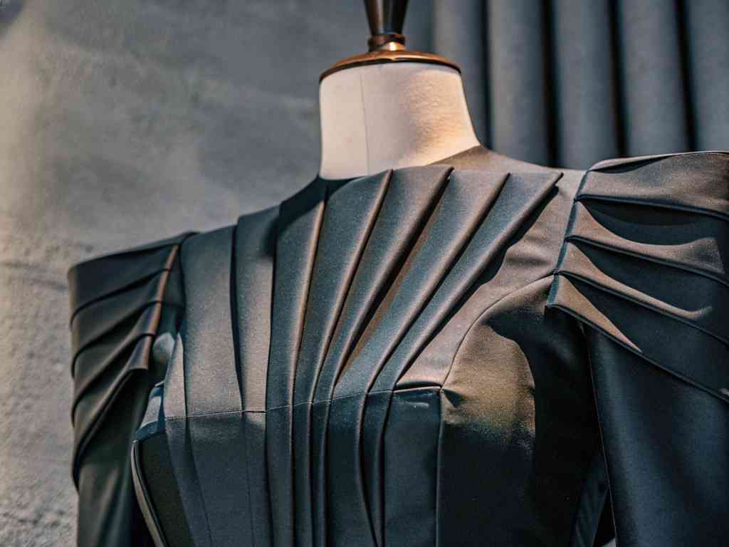 Black sculptural dress with sharp pleats on display