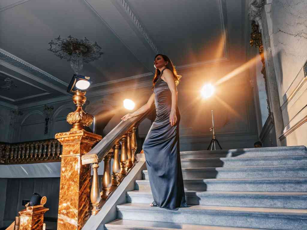 Elegant woman in evening gown on grand staircase