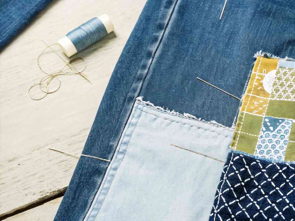 Patchwork fabric and blue thread with needles