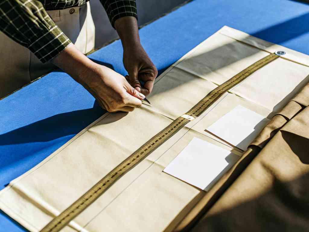 Designer marking beige pattern paper on blue table