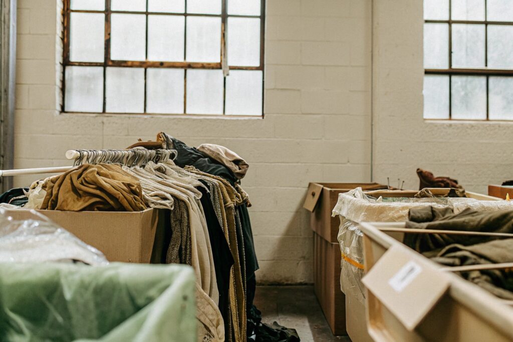 Piles of used clothes and bins in textile sorting area