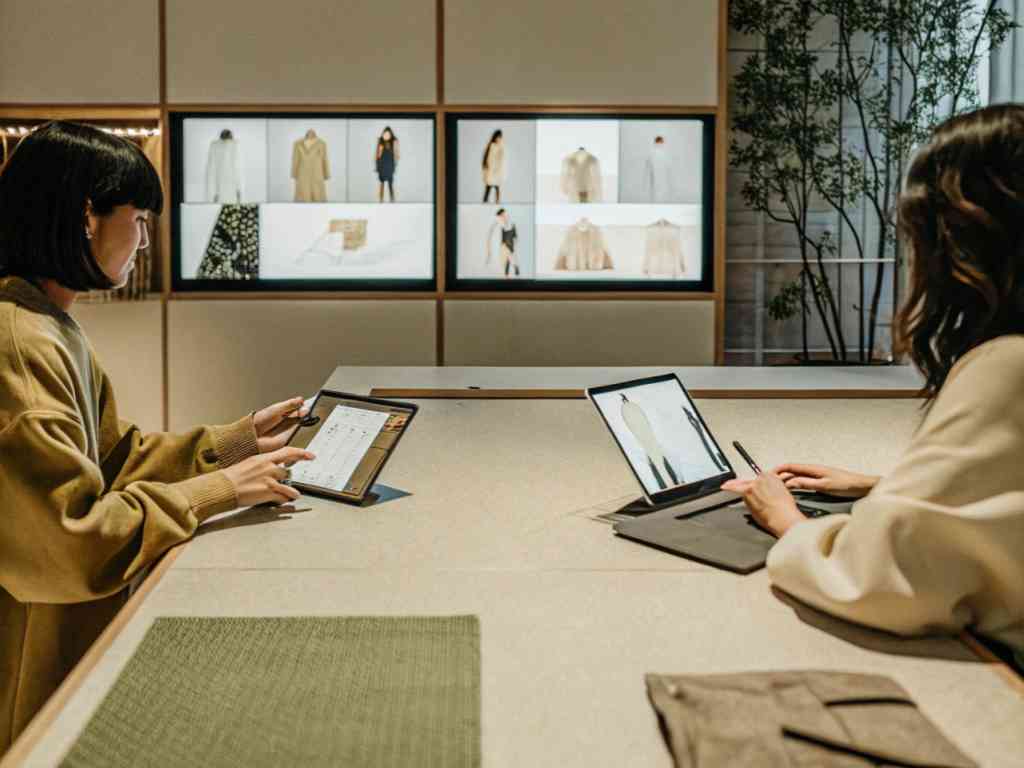 Fashion designers using tablets to sketch clothing concepts