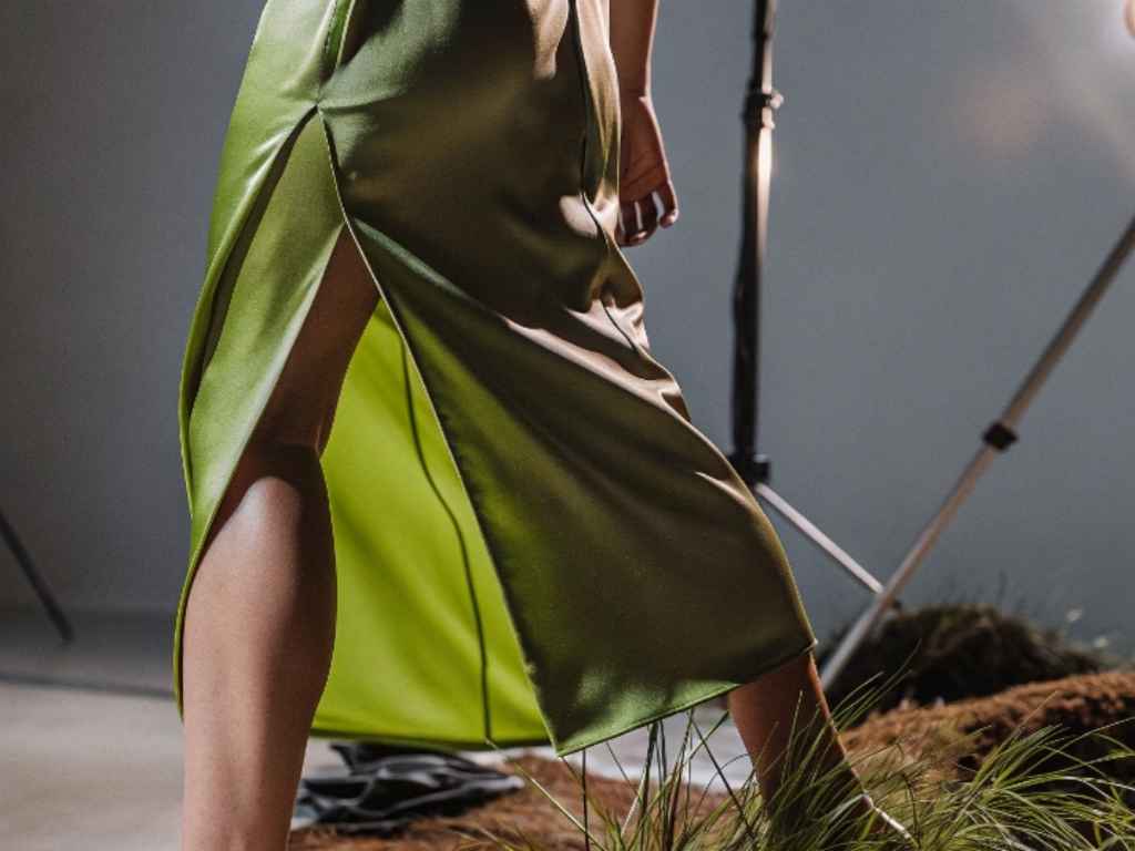 Green satin skirt with thigh-high slit under studio lighting
