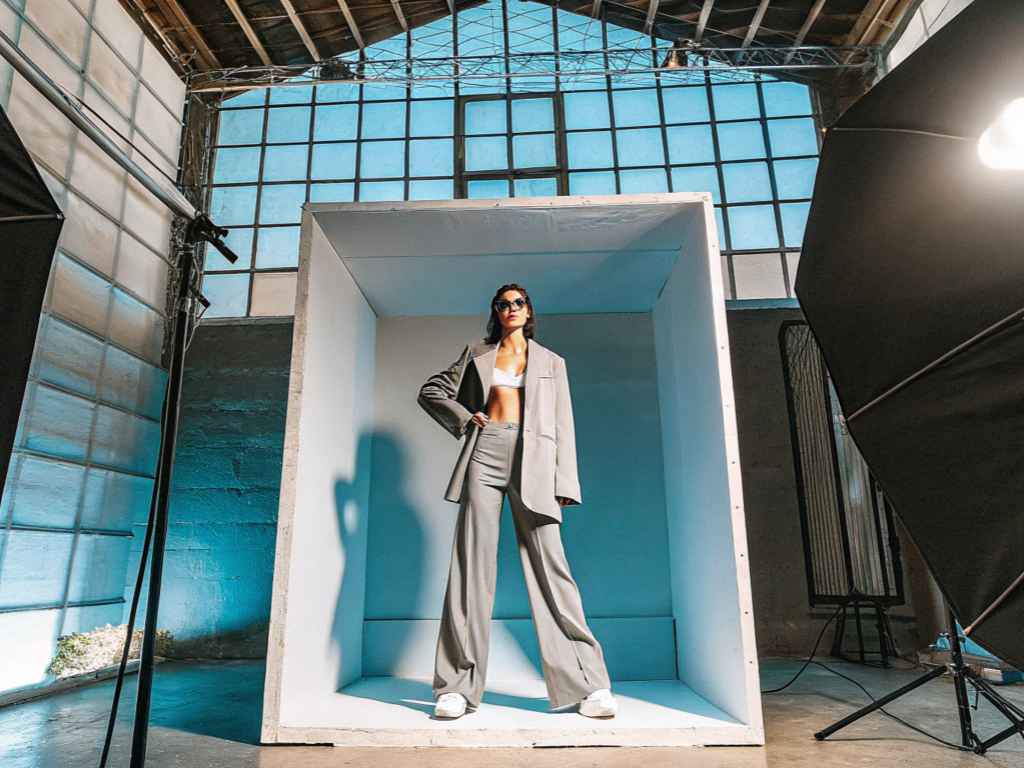 Model posing in gray suit with bralette in studio setup