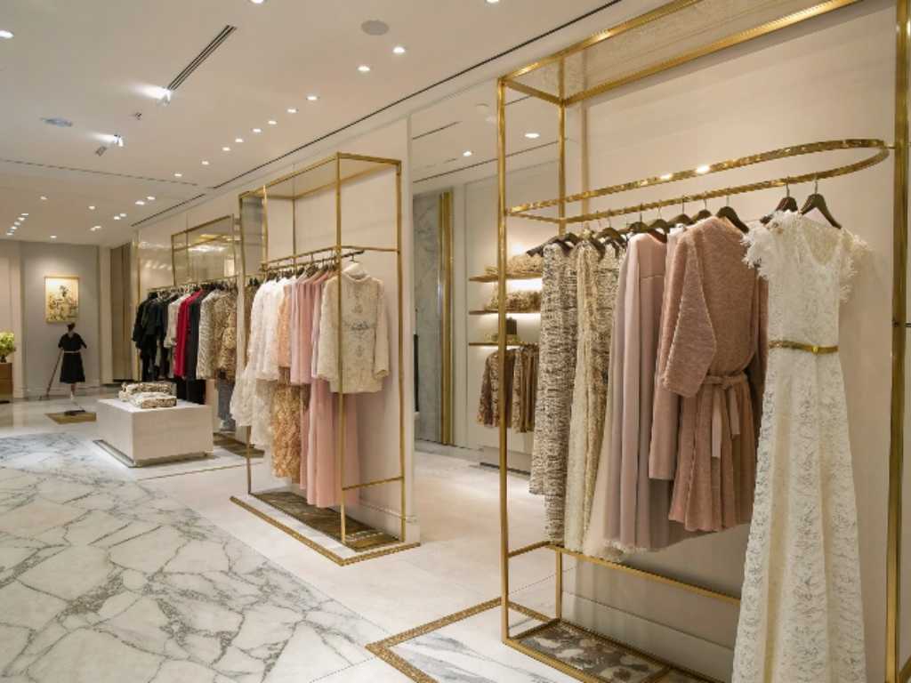 Boutique with gold clothing racks and elegant women’s dresses.