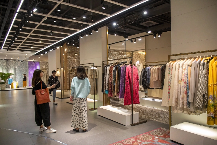 High-end boutique displaying jackets, dresses, and women shopping inside.