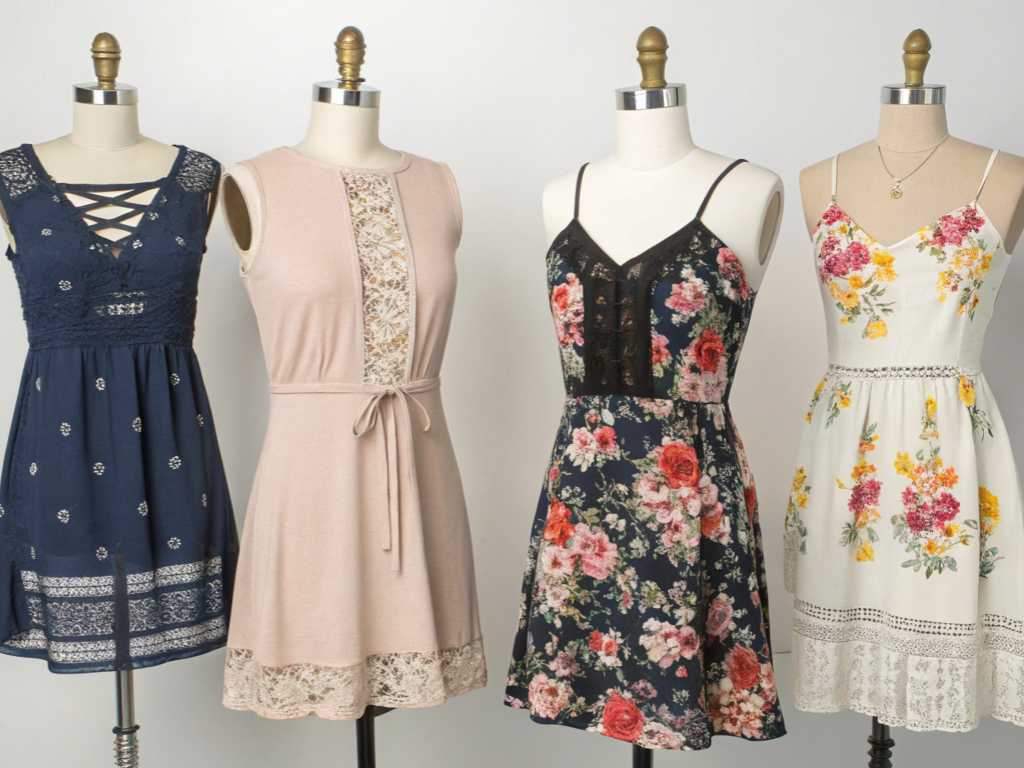 Four floral and lace-trimmed dresses displayed on mannequins.