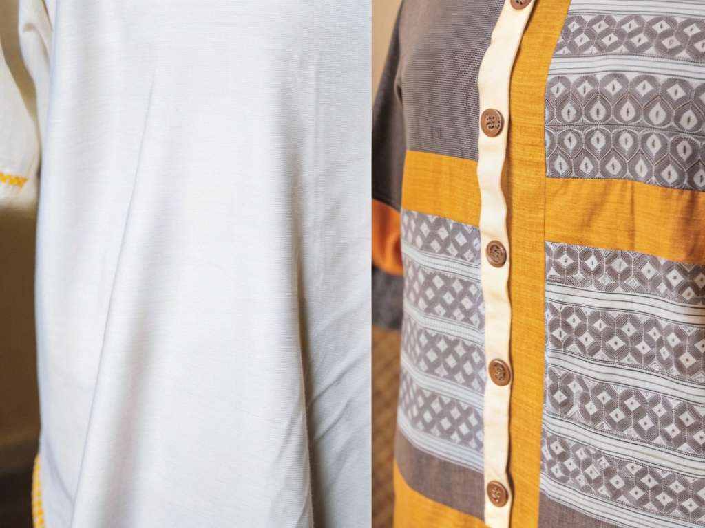 Close-up of plain white fabric and patterned shirt with wooden buttons.
